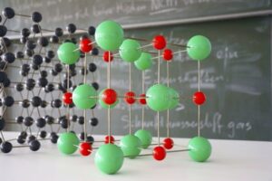 Modell eines Molekülgitters vor einer Tafel im Klassenzimmer