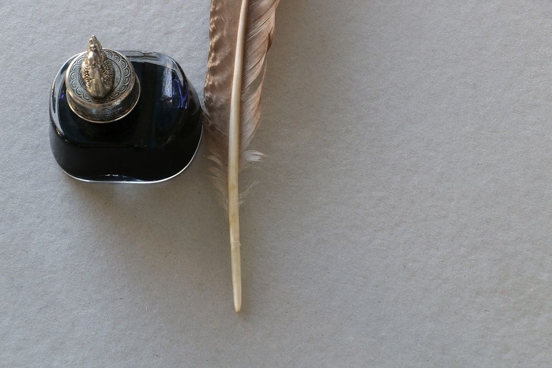 Historischer Tintenhalter mit Feder als Symbol dichterischen Schreibens