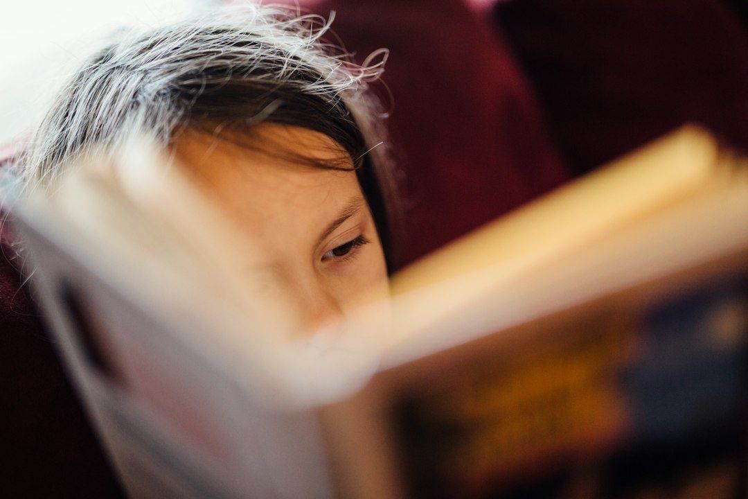 Jugendliche Person liest konzentriert in einem Buch